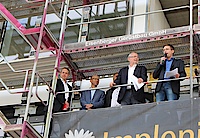 Fünf Männer stehen auf einem Baugerüst und ein Mann in der Mitte hält eine Rede.